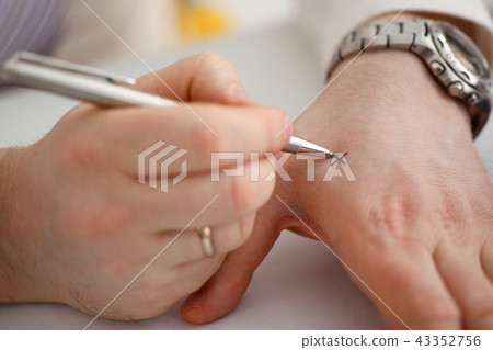 Male make x cross note with silver pen at his arm 43352756