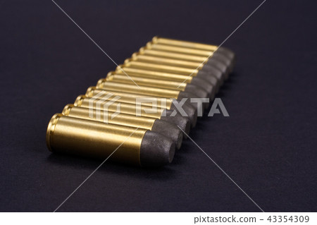 Wild West Revolver cartridges on black background 43354309