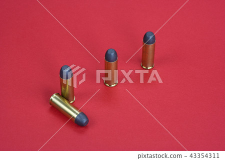 Wild West Revolver cartridges on red background Wild West Revolver cartridges on red background 43354311