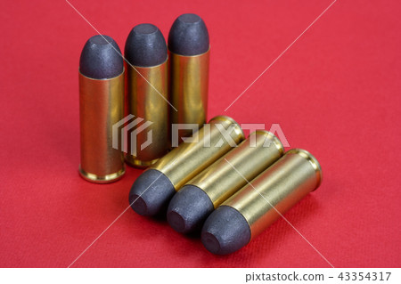 Wild West Revolver cartridges on red background Wild West Revolver cartridges on red background 43354317