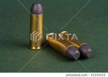 Wild West Revolver cartridges on green background 43354323