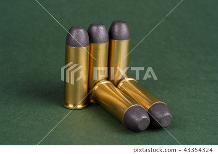 Wild West Revolver cartridges on green background Wild West Revolver cartridges on green background 43354324