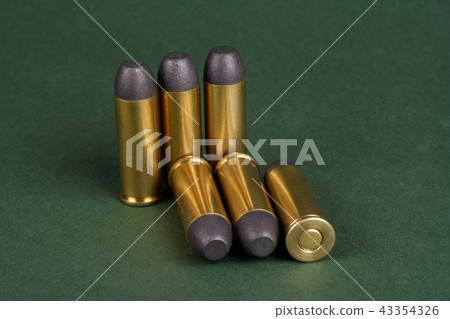 Wild West Revolver cartridges on green background Wild West Revolver cartridges on green background 43354326