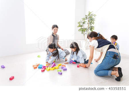 Child and teacher playing with blocks 43358551