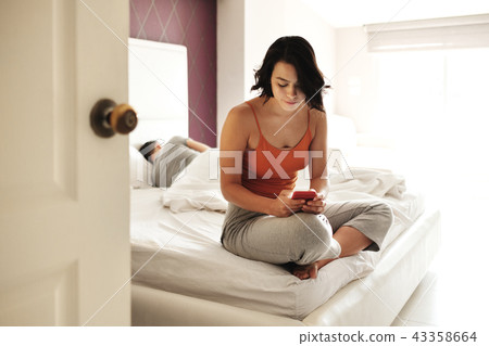 Woman Cheating Her Man Texting On Smartphone 43358664