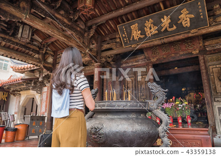 asian lady standing in front of the censer. asian lady standing in front of the censer. 43359138