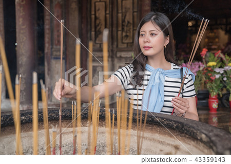 pretty asian woman offering incense to gods. 43359143
