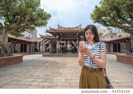 asian tourist looking for something by the phone asian tourist looking for something by the phone 43359150
