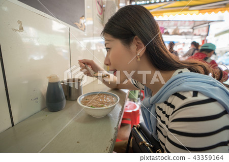 woman eating food in traditioanl old street. woman eating food in traditioanl old street. 43359164