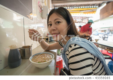 asian visitor eating tranditinal food. asian visitor eating tranditinal food. 43359165