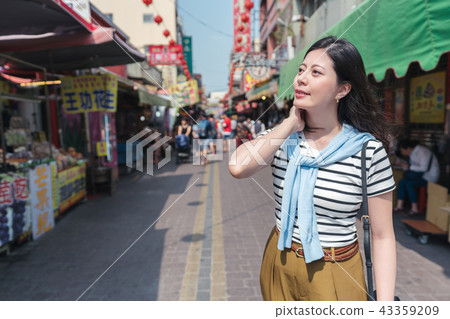 asian female smiling and standing in the street. 43359209