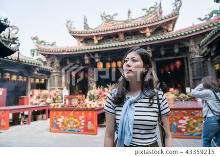 asian woman standing and looking around in the temple. asian woman standing and looking around in the temple. 43359215