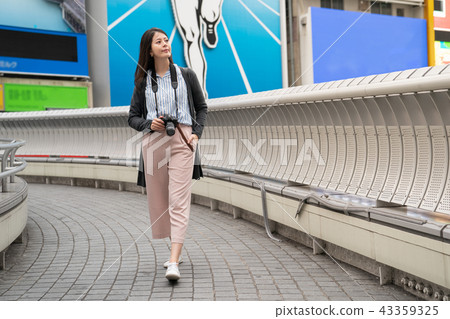 asian female holding a camera on the bridge. 43359325