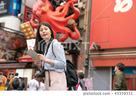 asian female holding a map and looking for a place. asian female holding a map and looking for a place. 43359331