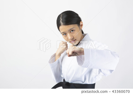 一個女性的空手道，用一個嚴肅的表情發出一拳 43360070