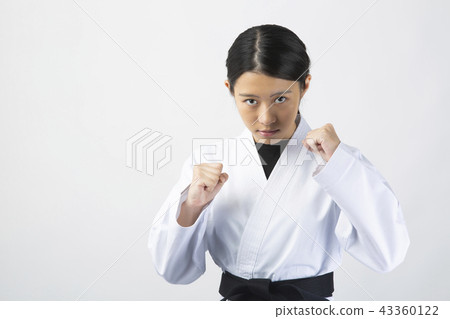 A female karateka who holds a fist with a serious expression 43360122