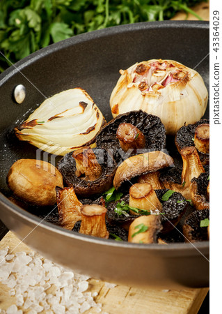 fried mushrooms on a hot pan on an old wooden table 43364029