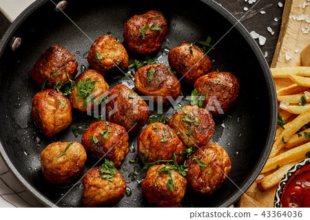 meat balls in a pan and golden crispy fries on a black old table meat balls in a pan and golden crispy fries on a black old table 43364036