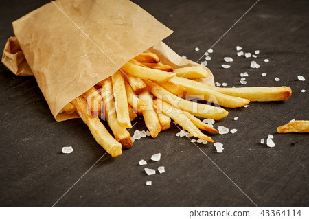 delicious and crispy fries in paper on a black old table 43364114