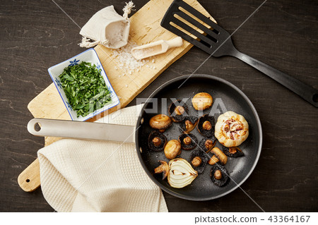 fried mushrooms on a hot pan on an old wooden table 43364167
