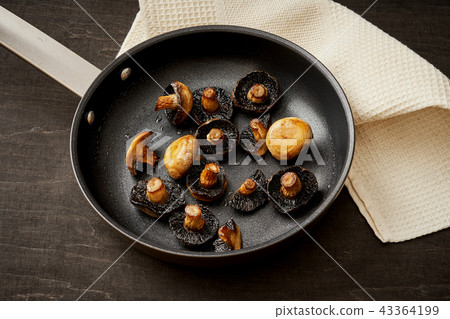 fried mushrooms on a hot pan on an old wooden table fried mushrooms on a hot pan on an old wooden table 43364199