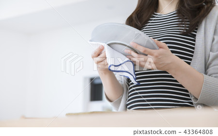 Young woman doing housework wipes dish body parts parts cut faceless 43364808