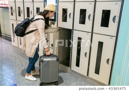woman putting her stuff in electronic locker. woman putting her stuff in electronic locker. 43365475