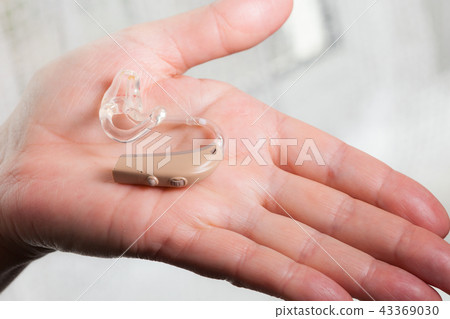 senior person holding hearing aid closeup senior person holding hearing aid closeup 43369030