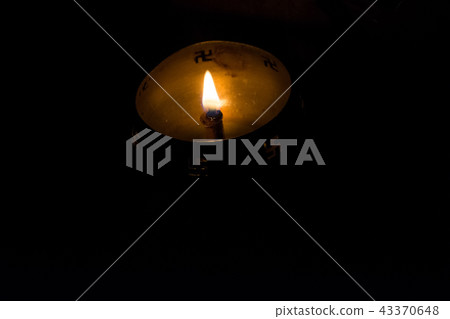 Flame of oil lamp on dark background 43370648
