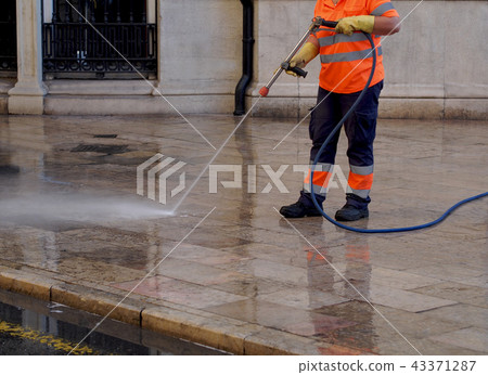 City workers - cleaning and washing of city street City workers - cleaning and washing of city street 43371287