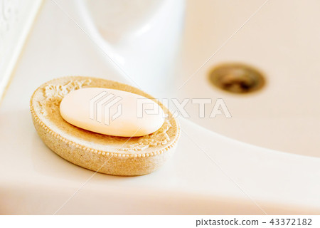 Soap on a dish over ceramic sink 43372182