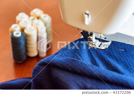 Dressmaker or seamstress works using sewing machine Dressmaker or seamstress works using sewing machine 43372206