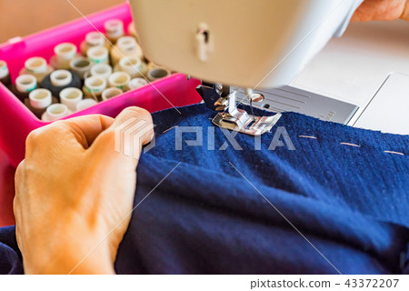 Dressmaker or seamstress works using sewing machine Dressmaker or seamstress works using sewing machine 43372207