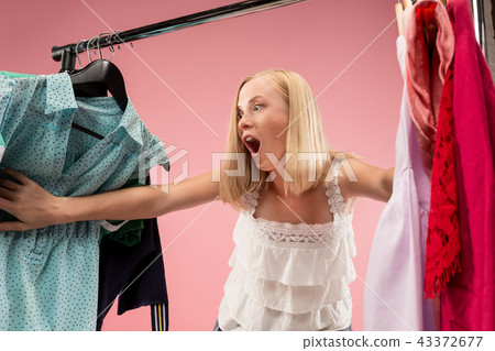 The young pretty girl looking at dresses and try on it while choosing at shop 43372677