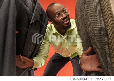 Handsome man with beard choosing shirt in a shop 43372728