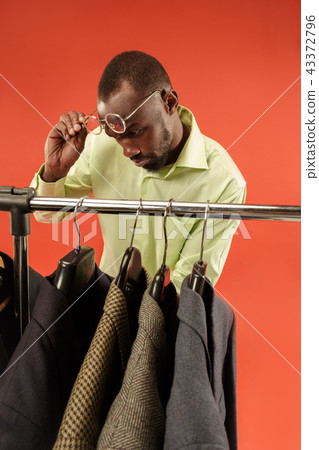 Handsome man with beard choosing shirt in a shop Handsome man with beard choosing shirt in a shop 43372796