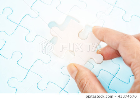hand holding a last piece puzzle. 43374570