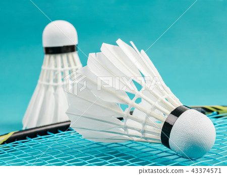 huttlecock and badminton racket on blue background huttlecock and badminton racket on blue background 43374571