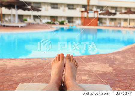 male feet on swimming pool background male feet on swimming pool background 43375377
