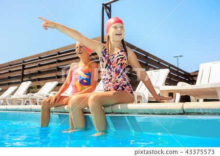 The portrait of happy smiling beautiful teen girls at the pool The portrait of happy smiling beautiful teen girls at the pool 43375573