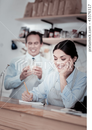 Relaxed waitress making notes and a waiter holding a glass Relaxed waitress making notes and a waiter holding a glass 43376317
