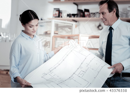 Curious engineers smiling and looking at the blueprint Curious engineers smiling and looking at the blueprint 43376338