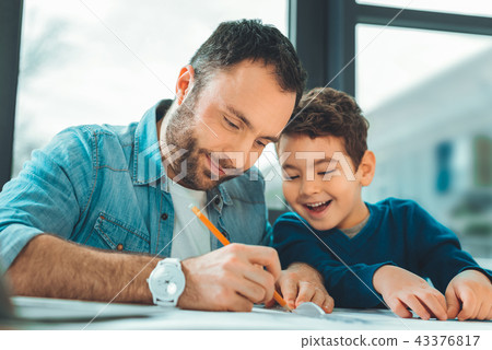 Positive delighted daddy spending time with son 43376817
