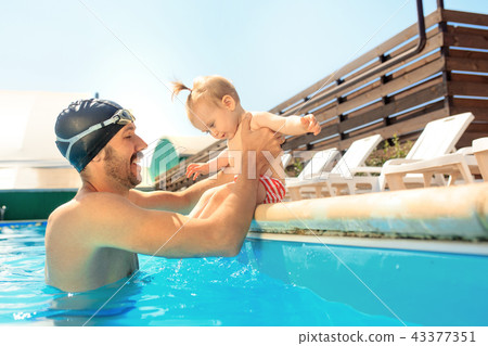 Happy family having fun by the swimming pool Happy family having fun by the swimming pool 43377351