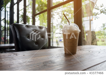 Iced cappuccino on wooden table beside in coffee - Stock Photo ...