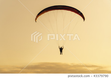 silhouette of paraplane on evening sky background, sunset time. 43379790