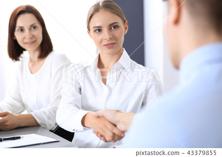Business handshake by blonde woman and her partner at meeting. Concept of success and agreement Business handshake by blonde woman and her partner at meeting. Concept of success and agreement 43379855