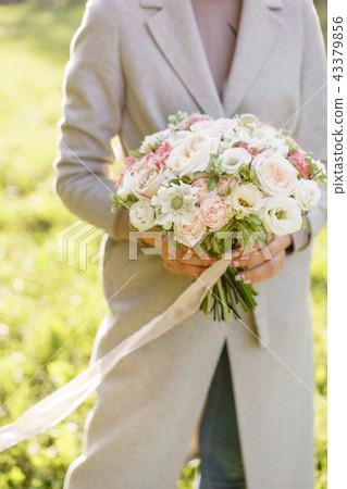 Young girl holding a beautiful spring bouquet. flower arrangement with garden roses. Color light Young girl holding a beautiful spring bouquet. flower arrangement with garden roses. Color light 43379856