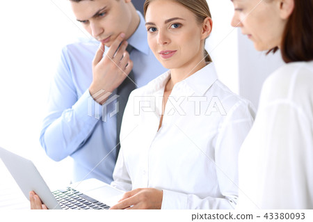 Group of business people using laptop computer while standing in office. Meeting and teamwork Group of business people using laptop computer while standing in office. Meeting and teamwork 43380093