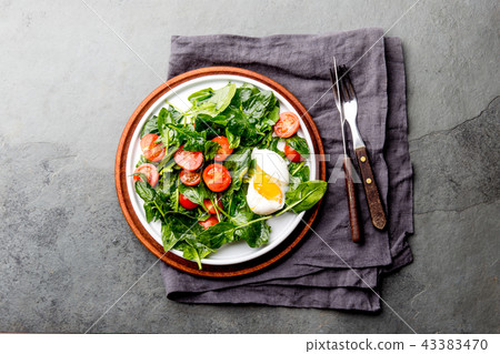 Fresh summer salad with baby spinach, tomatoes cherry and egg. Top view, copy space. Slate gray Fresh summer salad with baby spinach, tomatoes cherry and egg. Top view, copy space. Slate gray 43383470